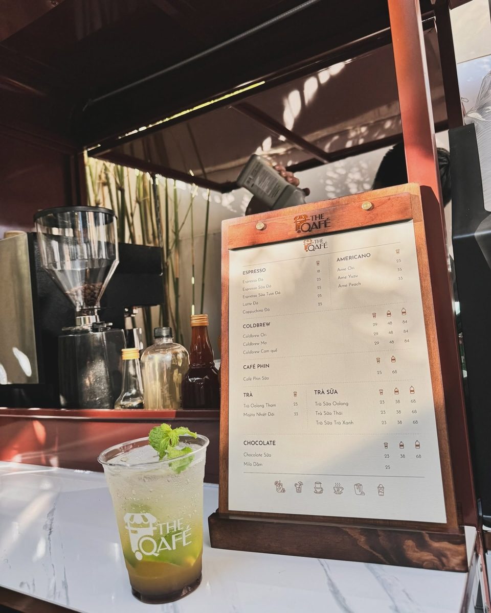 Bảng menu gỗ của The Qafé trên quầy xe